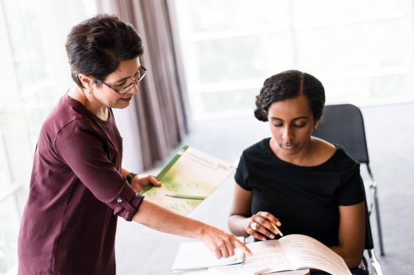 teacher showing student something on a piece of paper